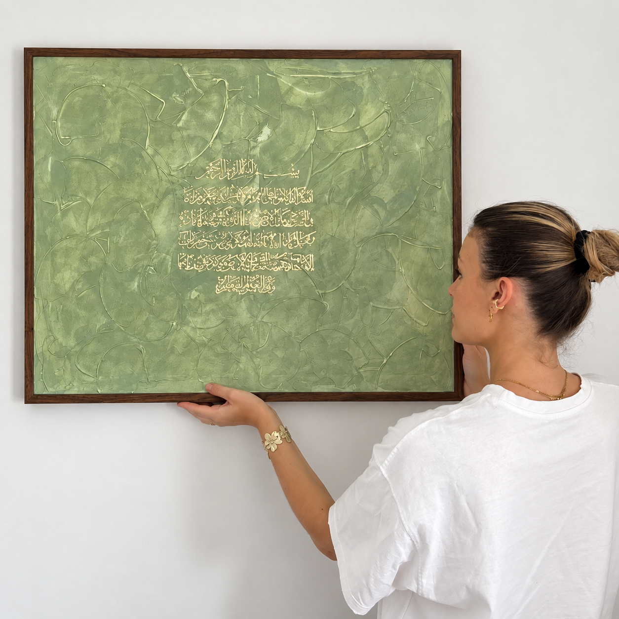 Inès Blaszczak présentant une œuvre de calligraphie arabe contemporaine encadrée, pour Alif Calligraphie